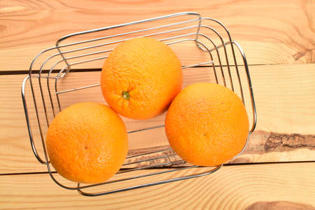 Bright yellow juicy, fresh, organic oranges, close-up, on a wooden table.の写真素材