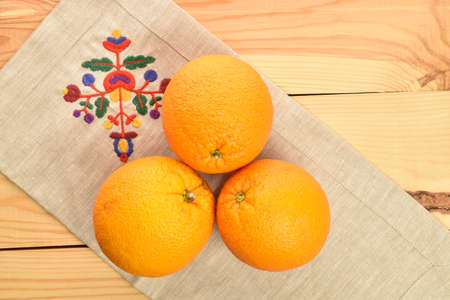 Bright yellow juicy, fresh, organic oranges, close-up, on a wooden table.の写真素材