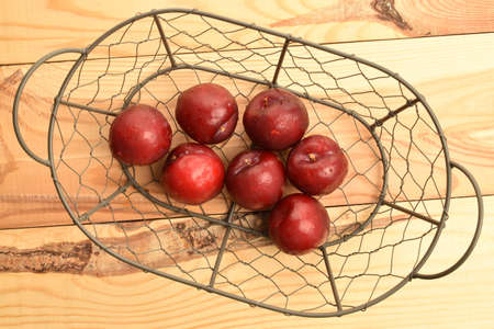 Juicy, tasty, organic red plum, close-up, on a wooden table.の写真素材