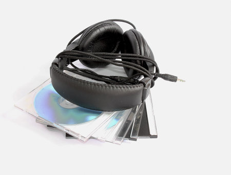 Headphones greater and black lay on CD disks on a white background 