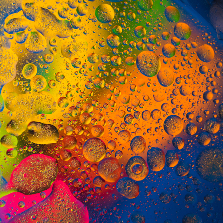 Abstract oil drops in the water against colorful background.の写真素材