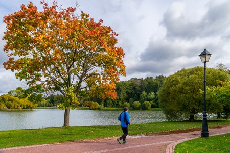 MOSCOW, RUSSIA - SEPTEMBER 29, 2018: Elderly man running in autumn parkのeditorial素材