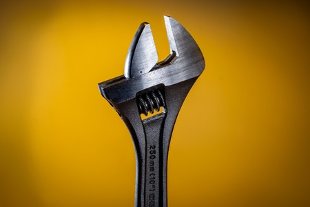 Adjustable wrench (spanner) on yellow backgroundの写真素材