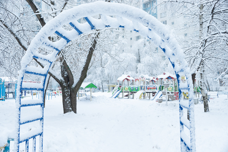 Childrens playground after snowfall near the residential house in Moscow, Russiaの写真素材