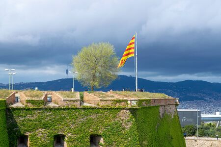 BARCELONA,SPAIN - APRIL 09, 2019: The Catalonian flag over Montjuic Castleのeditorial素材