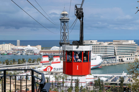 BARCELONA, SPAIN - APRIL 9, 2019.: Cable car with passengers over the portのeditorial素材