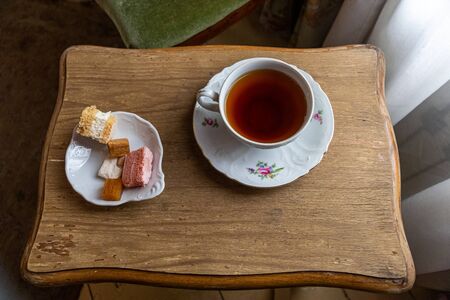 A cup of tea and various types of pastila on a tray on a small wooden tableの写真素材