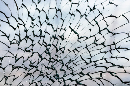 View of the cloudy sky through the shattered glass