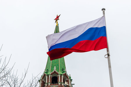 State flag of Russia against the Kremlin tower in Moscow
