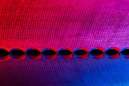 Macro image of the edge of blade of bread knife with reflection illuminated wred and blueの写真素材