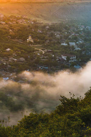 Slavic Moldova Russian church in a village at sunrise in spring with white smogの写真素材