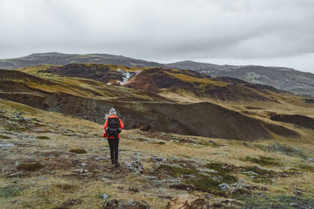 One woman wanders in Iceland with backpack in a red jacketの写真素材