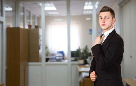 Funny young male businessman inside office background.  One person, dressed according to business dress code, located inside the office interiorの写真素材
