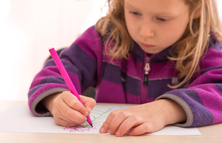 Child draws the picture with color pen. Serious, absorbed faceの写真素材