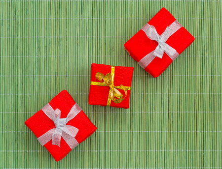 Three decoratively packed gifts on the green bamboo mat