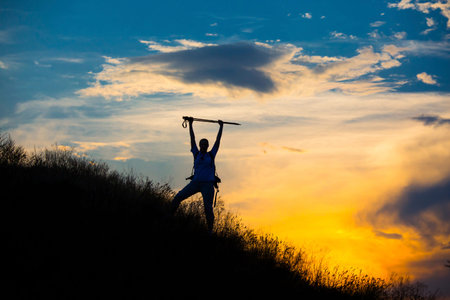 Female hiker silhouette with massive clouds on the background woman with raised handsの写真素材