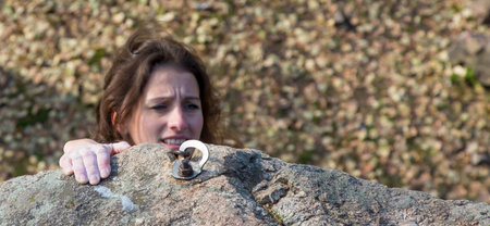 The last effort Brunette female climber tries to keep the hold. Very emotional faceの写真素材