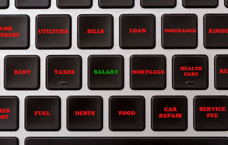 Expenses and incomes Conceptual image describing high cost pressure on household budget Computer keyboard with expenses listed on the buttons Black keyboardの写真素材