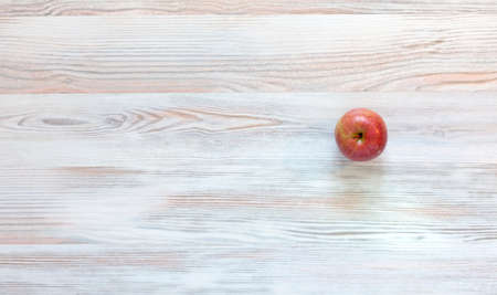 Red apple on wood background Bright red apple located on well-textured birch kind of woodの写真素材