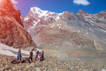 Hikers making stop rock trail in Nepal India Himalaya Way to high altitude famous attraction heavy luggage trekking gear mountain sunny day peaks backgroundの写真素材