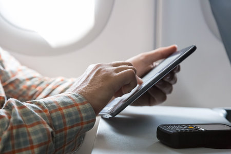 Person sitting inside airplane Window Seat Using Electronic Gadget Casual Clothing Bearded
