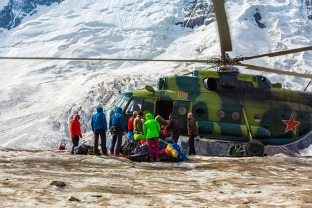Transport Helicopter Landing on Ice Field of Massive Mountain Glacier People Climbing Out and...