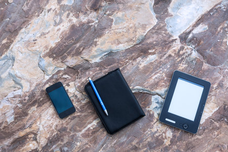 Business and Travel Items on Marble Granite Stone Background Telephone Notepad Pen Tablet PC...