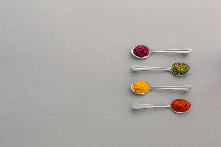 Image of Grey Metal Spoons with Selection of Aromatic Seasonings on Classic Grey Wooden Backgroundの写真素材