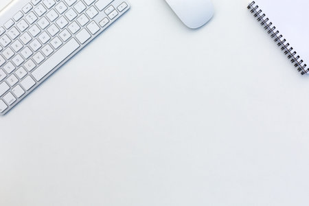 Image of White Office Desk with Computer Keyboard Mouse and Notepad from aboveの写真素材