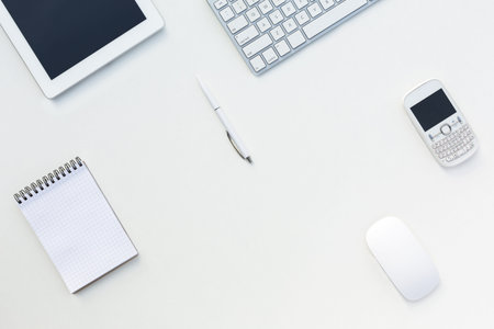 White Office Desk Table with Computer Keyboard Tablet PC Cell Phone Mouse Notepad and Pen Responsive Mock Up Template Electronic Gadgets and Stationeryの写真素材