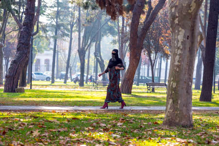 An attractive Young woman wearing a colorful head covering and Muslim Dress Walking in University Parkの写真素材