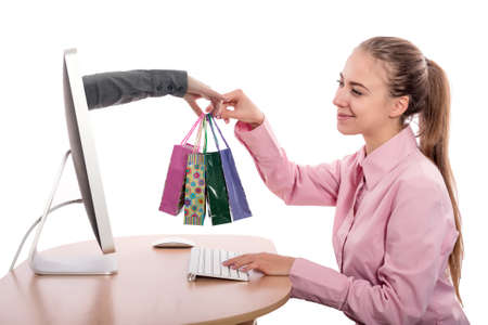 Internet Shopping and fast Delivery young Woman makes Order at Computer and Hand of Agent appears from Screen instantly completing the Deal on white Backgroundの写真素材