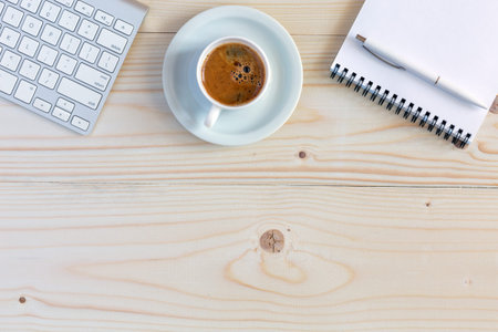 Business Composition with cropped Computer Keyboard Notepad and Pen Cup of Coffee and blank Business Card on natural Wood Tableの写真素材