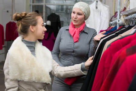 Saleslady showing Variety of Jackets to Customer in Retail Storeの写真素材