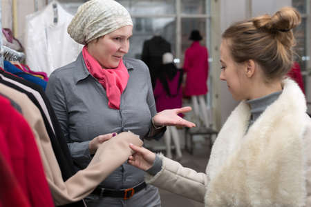 Saleslady showing Variety of Jackets to Customer in Retail Storeの写真素材