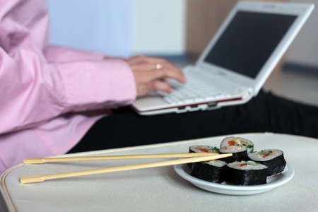 Set of Sushi and Body of Female working on Laptopの写真素材
