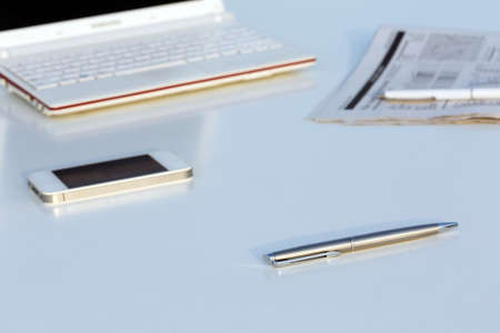 Angle View of Work Place with Laptop Pen and Newspaperの写真素材