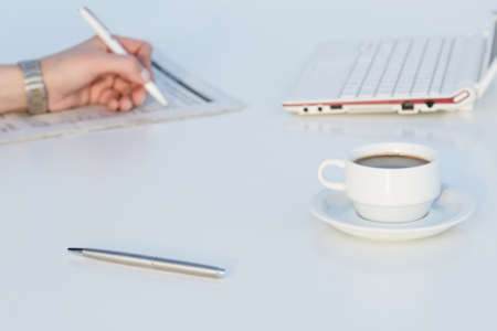 Angle View of Work Place with Laptop Color Pencils and Business Newspaperの写真素材