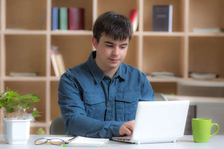 Young male Freelancer Professional working at desk in warm interiorの写真素材