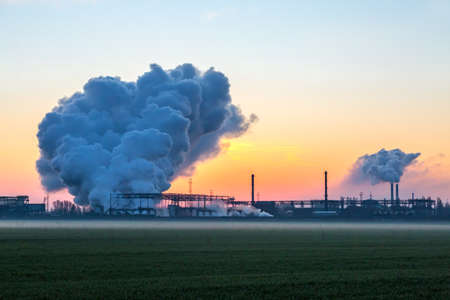 Smoke Stack from Chimney of Chemical Plant at Sunriseの写真素材