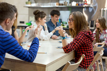 Many Students sitting at Wood Table of Campus and talkingの写真素材
