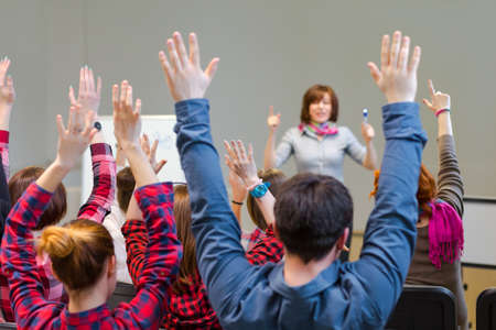 Active Students raising Arms up ready to answer Teachers Questionの写真素材