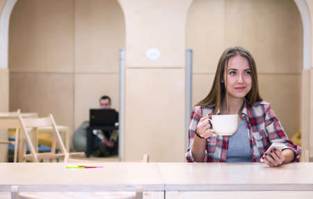 College Campus Kitchenette Area and young Lady drinking Teaの写真素材