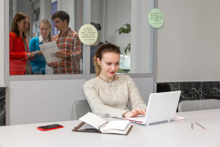 Cute female Freelancer working on Laptop in open Space Officeの写真素材