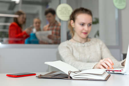 Cute female Freelancer working on Laptop in open Space Officeの写真素材