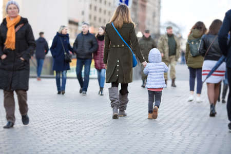 Mother and Daughter walking on City Street among Crowdの写真素材