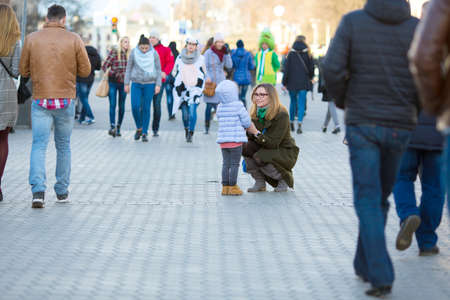 Mother and Daughter walking on City Street among Crowdの写真素材