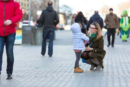 Mother and Daughter walking on City Street among Crowdの写真素材