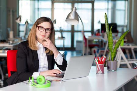 Beautiful Business Lady in official clothing working on Laptopの写真素材