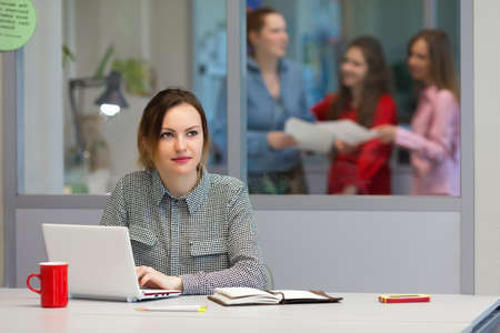 Young female Trainee working on Laptop in Office Interiorの写真素材